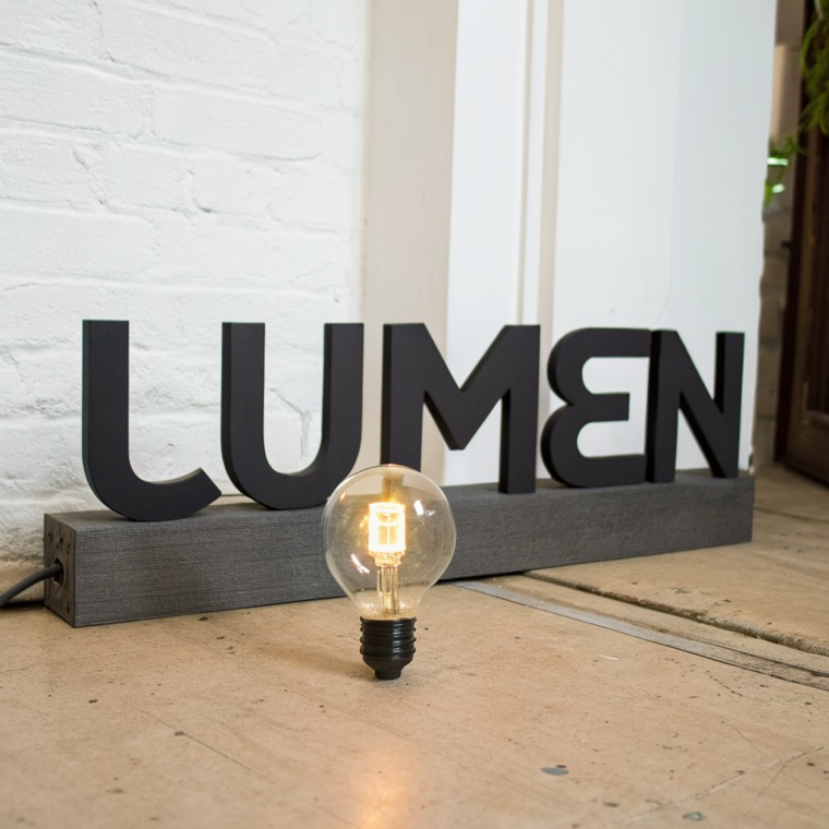 wordmark for “LUMEN”, bold grotesk, lightbulb hidden in the U